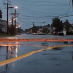 Street scene with downed power lines and wet pavement, illustrating storm damage and emergency electrical service needs.